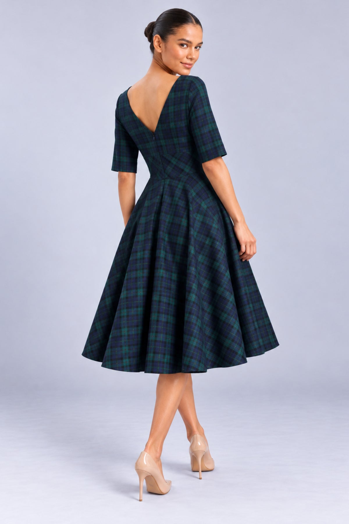 Back view of the Hepburn Forest and Navy Plaid Swing Dress, featuring the elegant V-back neckline and full circle tartan skirt.