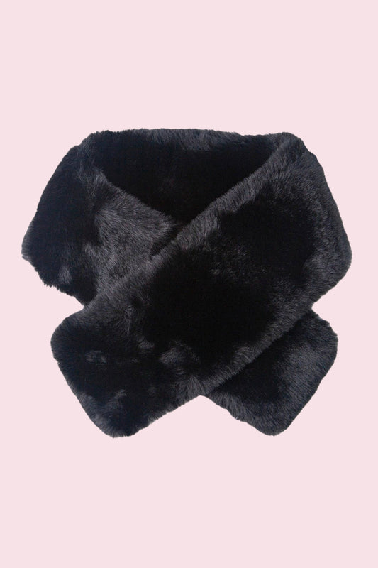 A black faux fur scarf or neck warmer, styled in a crossed loop, shown against a solid pale pink background.